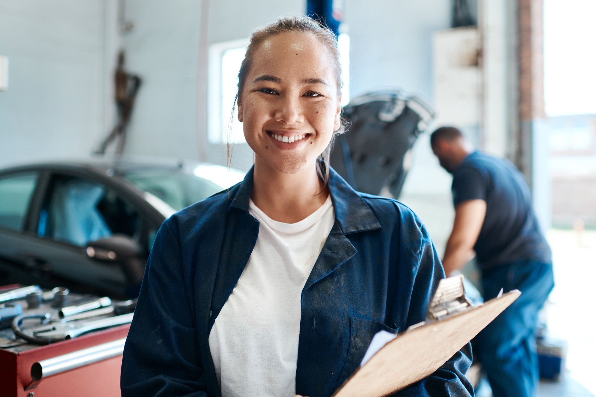 Shot of a female mechanic holding a clipboard while working in an auto repair shop