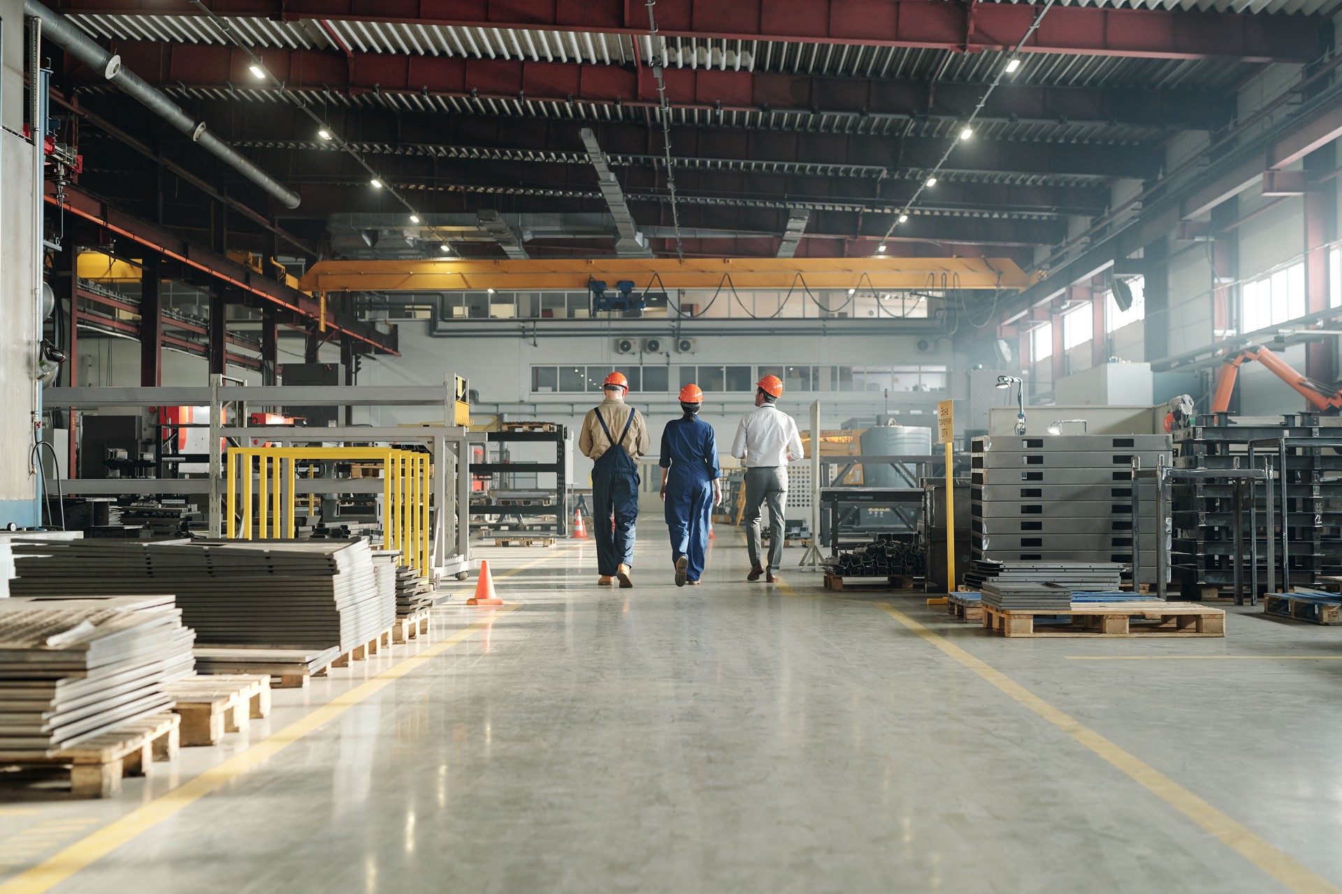 Rear view of three engineers leaving workshop at the end of working day